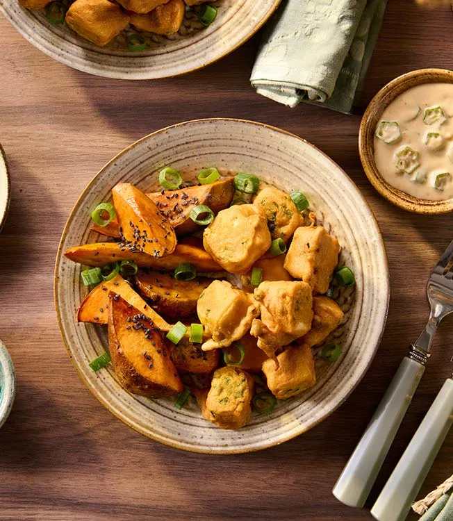 Tofu enrobé dans une panure de jalapeño, servi avec des okras et une sauce coco-cacahuète